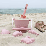 Scrunch Sand Moulds - Old Rose (Footprints Set), lifestyle shot on beach with bucket & spade