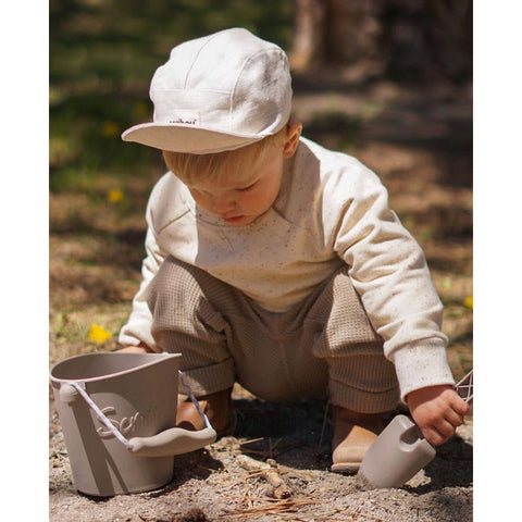 Scrunch bucket and spade mushroom, lifestyle shot with boy in cap digging