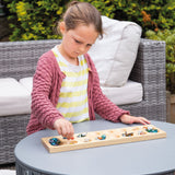 Mancala, girl playing game outside on table