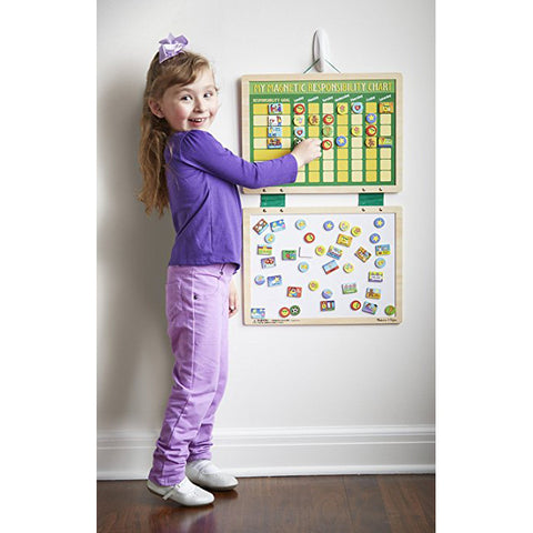 My Magnetic Responsibility Chart hanging on wall with girl posing next to it. 