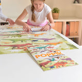 Poppik Poster & Stickers - Dinosaurs, girl completing poster, pack in foreground