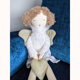 Evie Wilberry Doll sitting on blue teal chair 