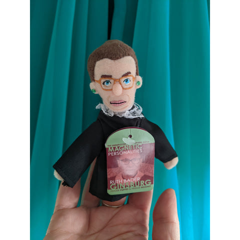 Ruth Bader Ginsburg Finger Puppet , posed on hand, green backdrop