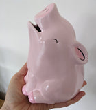 Greedy Piggy Bank posed in adult female hand
