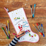 Colour -in Christmas Stocking, festive scene being completed by child's arm, pens visible