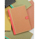 Orange Neon Kraft Notebook, with background of green & other notebooks